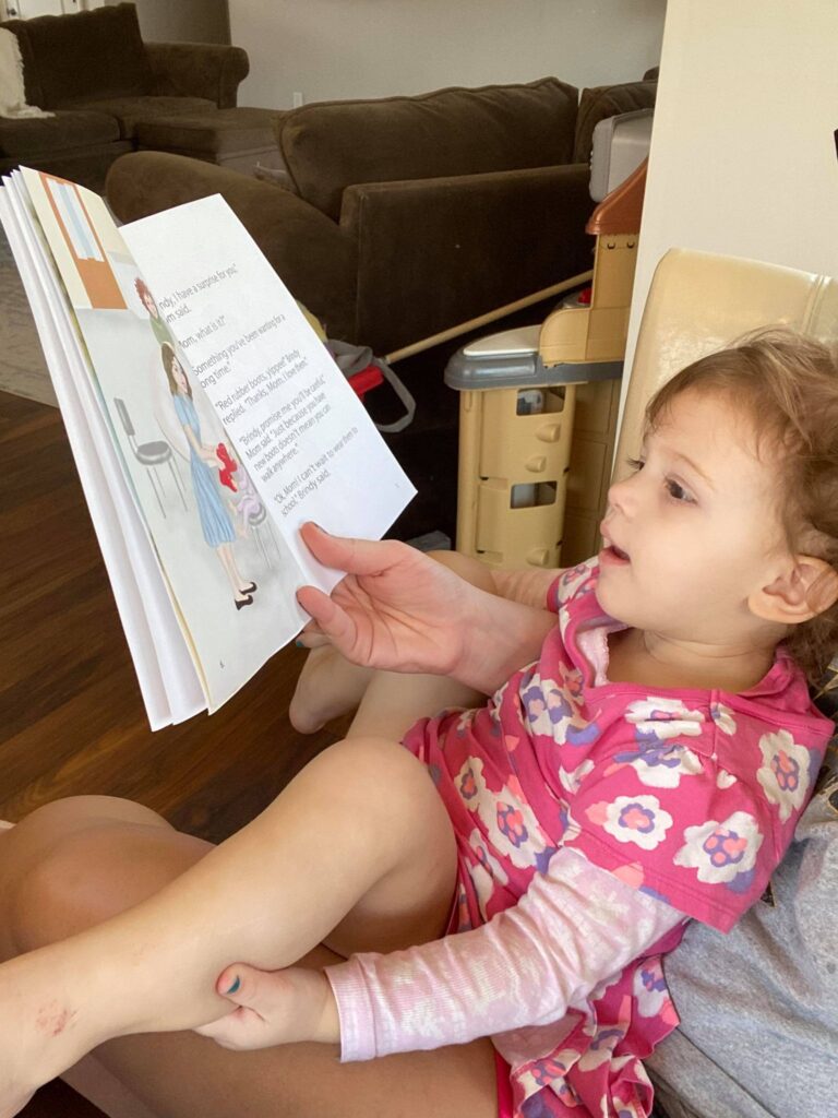 Avery reading Brindy and the Red Rubber Boots Children's Book